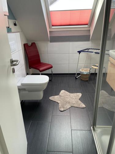 诺德奈Haus Julianne, Wohnung Backbord, Familie Poppinga的一间带卫生间和红色椅子的浴室