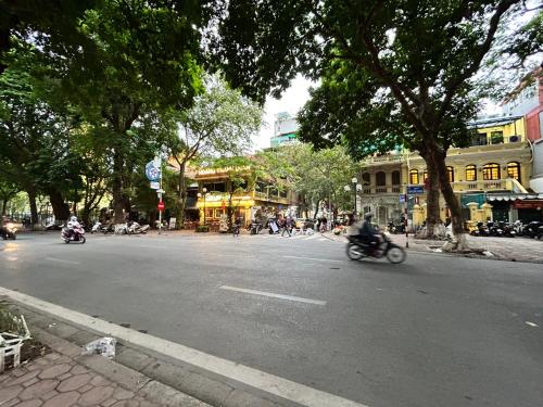 河内NHÀ AN的骑摩托车沿着城市街道的人