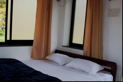 巴加Hotel innovation inn的卧室配有带2个枕头的床铺和窗户