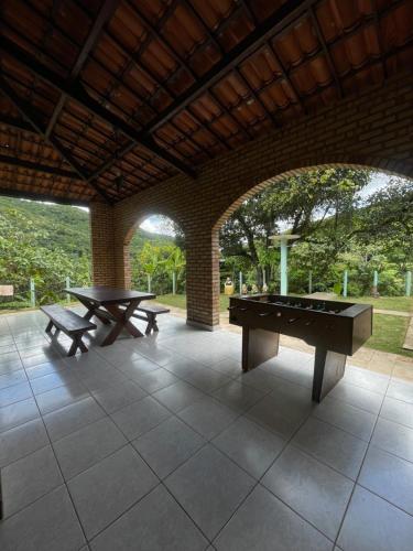 穆隆古Casa na serra de mulungu的天井设有2张乒乓球桌和2张长椅