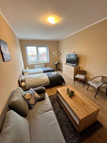 格丁尼亚Gdynia Pokoje Blisko Morza i Centrum的一间带两张床和一张沙发的客厅