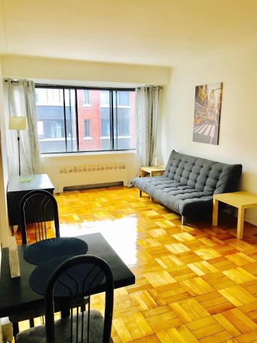 蒙特利尔Stylish Montreal Apartment: Comfortable Stay in the Golden Square Mile的客厅配有沙发和桌子