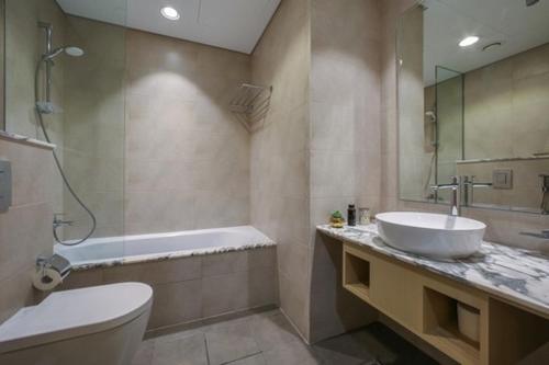 迪拜Luxurious one bedroom Apartment的一间带水槽、浴缸和卫生间的浴室
