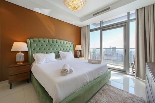 迪拜Luxurious one bedroom Apartment的一间卧室设有一张大床和大窗户