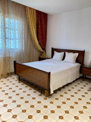 纳布勒Slama的卧室配有1张床,铺有瓷砖地板。
