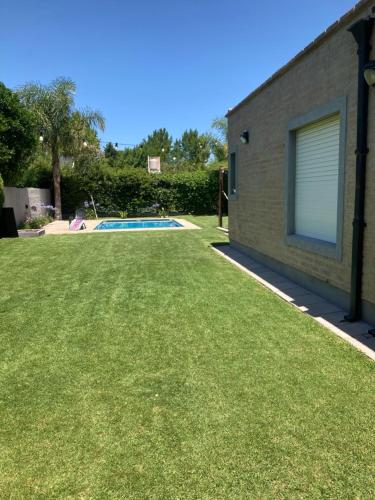 圣罗莎Casa quinta con pileta的一个带游泳池和草地的庭院