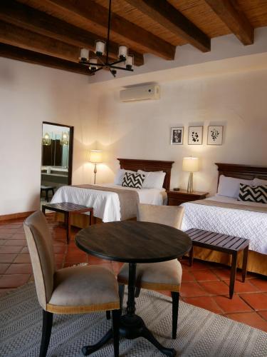 帕拉斯德拉富恩特Hotel El Farol的一间卧室配有两张床和一张桌子及椅子