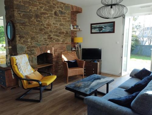 布雷斯特Maison de Kerangall的带沙发和石制壁炉的客厅
