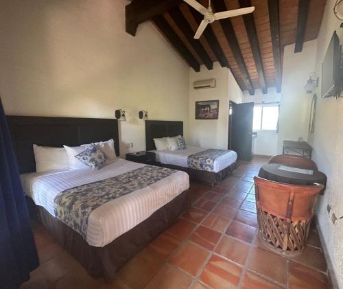 CosaláHotel Quinta Minera的酒店客房设有两张床和天花板