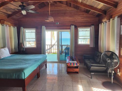 Seine Bight VillageCoco's Beachfront Cabanas的一间卧室配有一张床、一个风扇和一张沙发