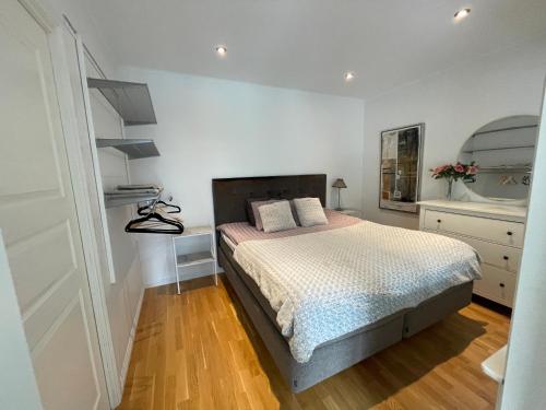 斯德哥尔摩nikos house;的一间铺有木地板的白色卧室,配有一张床