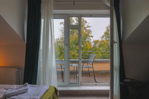 吕贝克K-UNITs: Lübeck Roter Löwe - City Nahes Appartement的一间卧室设有一扇门,可通往带椅子的阳台