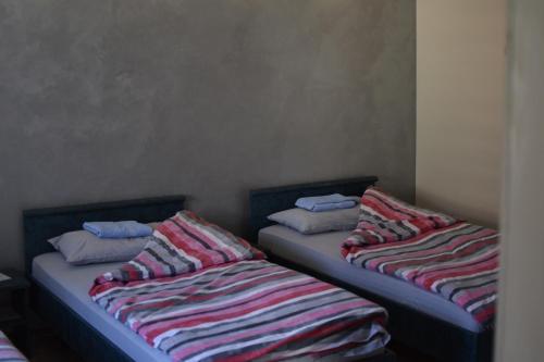 KuršumlijaKonak Garavi sokak的两张睡床彼此相邻,位于一个房间里