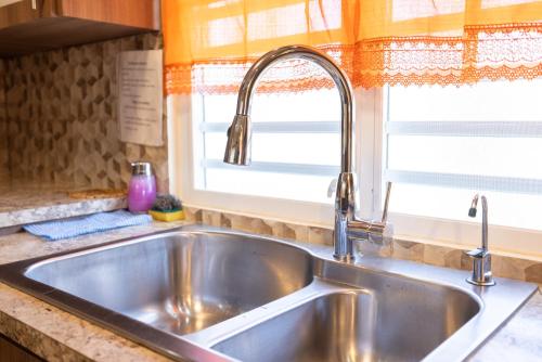 伊莎贝拉Arenales Vacational House的厨房里的一个不锈钢水槽,窗户