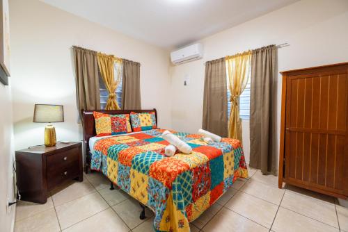 伊莎贝拉Arenales Vacational House的一间卧室配有一张带五颜六色棉被的床