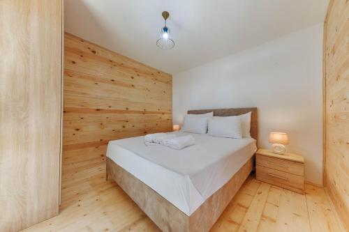 乌尔齐尼Family Bungalows的一间卧室配有一张木墙床