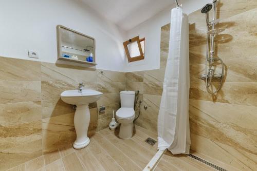 乌尔齐尼Family Bungalows的浴室配有卫生间、盥洗盆和淋浴。