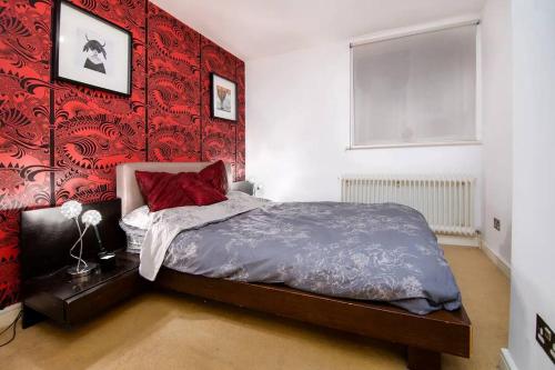 伦敦2BR flat next to London Eye on lower marsh 96A的一间卧室配有一张红色墙壁的床