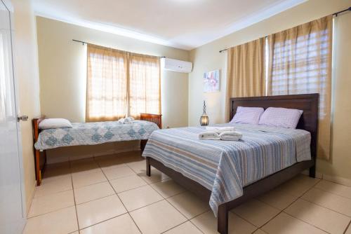 伊莎贝拉Colinas Del Atlantico 2 floors的一间卧室设有两张床和窗户。