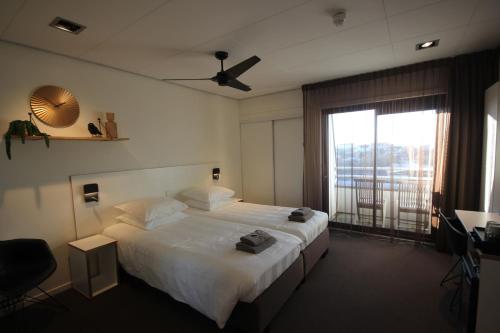 海滨诺德韦克Hotel Hogerhuys - adults only的一间卧室设有一张床和一个大窗户