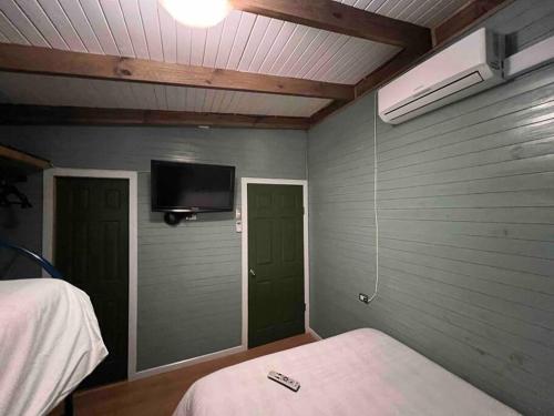 奥克泰港Espectacular Tiny House,terraza,Aire acondicionado的卧室配有一张床,墙上配有电视。