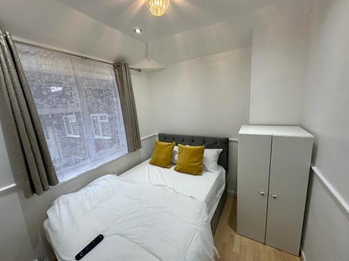 布罗姆利Cosy Smart/Small Double Room in Keedonwood Road Bromley的一间小卧室,配有两张床和窗户