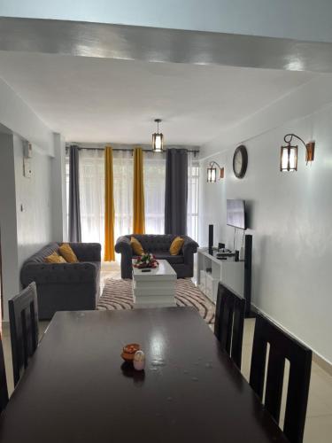 KerichoZoe Homes Oak Villa Apartment 1 and 2 Bedroom 201的客厅配有桌子和沙发