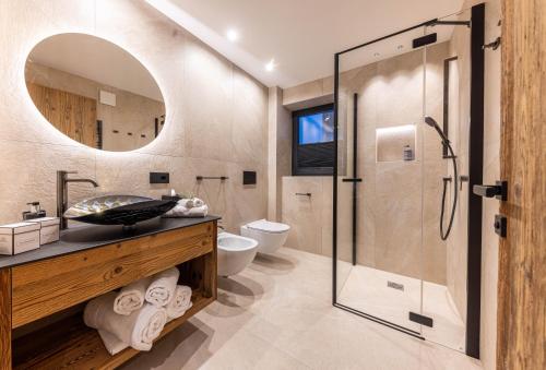 圣克里斯蒂娜Enjoy Dolomites - Chalet的一间带玻璃淋浴和水槽的浴室