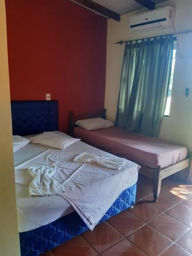 HernandariasHotel-Balneario Acuamanía的两张睡床彼此相邻,位于一个房间里
