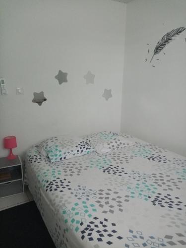 库鲁Un T2 climatisé, une nuit的卧室配有一张灰星床,墙上挂着灰色的星星