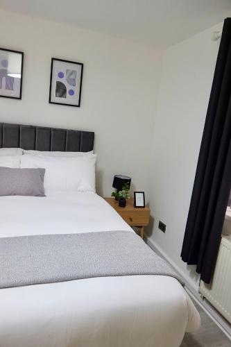 伯明翰Villa Retreat Birmingham的卧室配有白色的床和桌子