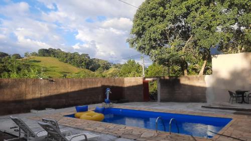 索科罗chácara Gato de Botas的院子里的游泳池周围设有椅子