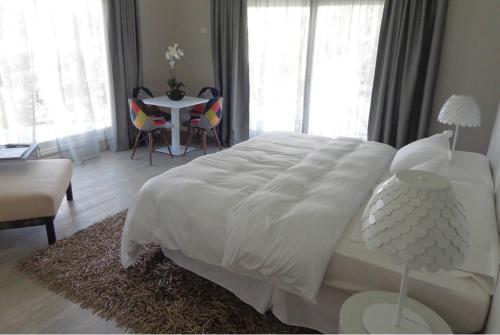 埃斯特角城Solanas Forest Semana的卧室配有白色的床和桌椅