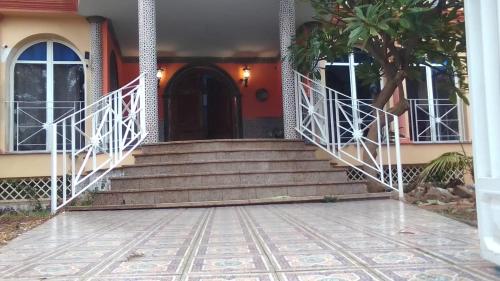 贝纳尔马德纳ESTRELLA LOUNGE的房屋设有通往前门的楼梯