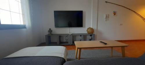 阿里纳加Casa Faro de Arinaga的带沙发、桌子和电视的客厅