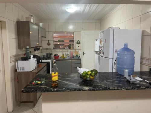 弗洛里亚诺波利斯Lohighfive的厨房配有带一瓶和一碗水果的吧台