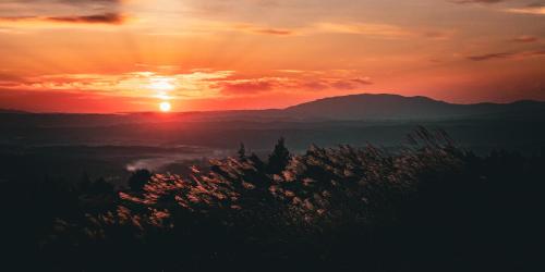 天空の宿 ロッジカウベル Lodge Cowbell的日落和日落,在群山上