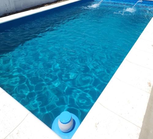 MacoC & J Casa de alquiler的一个蓝色的水游泳池,里面装有桶子
