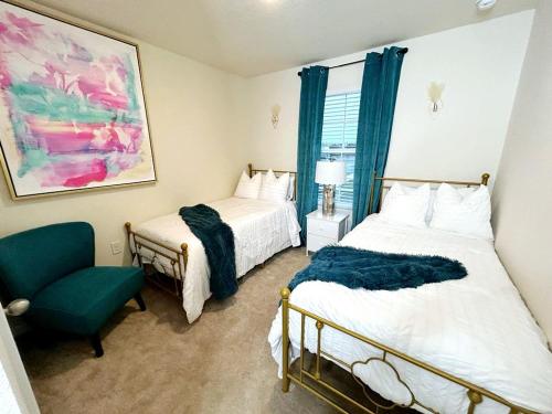 橘园Orange Park Townhome Vacation Rental with Patio!的一间卧室配有两张床和一张绿色椅子