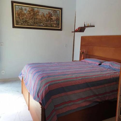 塞古罗港Tiny house的一间卧室配有一张床,床上有条纹毯子