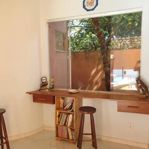 塞古罗港Tiny house的客房设有一张带两张凳子的桌子和一扇窗户。