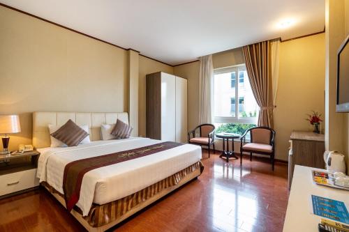 胡志明市La Palma Boutique Hotel的酒店客房设有一张大床和一张桌子。