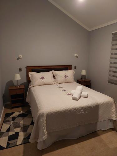纳塔列斯港Casa Isabella的一间卧室配有一张带2个床头柜的大型白色床
