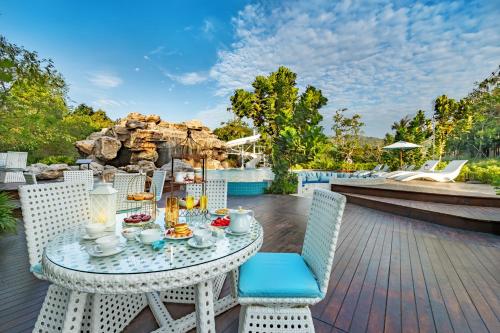 华欣Phukalini Luxury Pool Villa & Onsen-SHA Plus Certified的甲板上摆放着食物的桌子