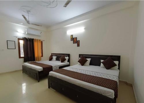 AyodhyaHotel The Ramam的一间带两张床和一张沙发的卧室