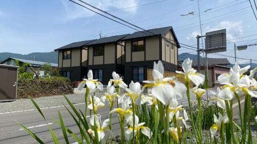 富士河口湖Holiday home Furinkazan 風林火山的街道前有白色花的房屋