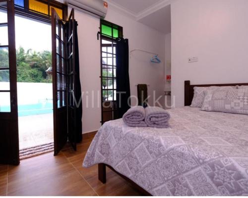 巴西富地Villa Tokku的一间卧室配有一张床,上面有两条毛巾