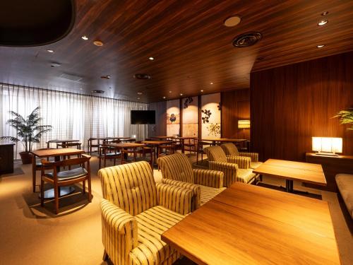 秋田ANA Crowne Plaza Akita, an IHG Hotel的餐厅设有桌椅和木墙