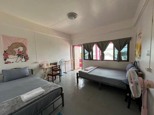 甲米镇Madam Guesthouse的一间卧室配有两张床和一张桌子