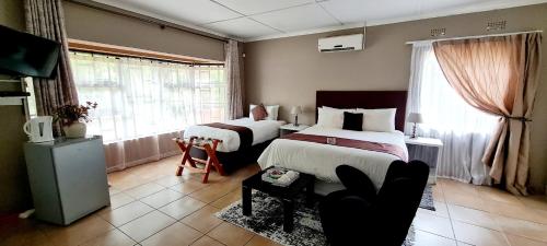 马翁Thamalakane guest house的酒店客房,设有两张床和一张沙发